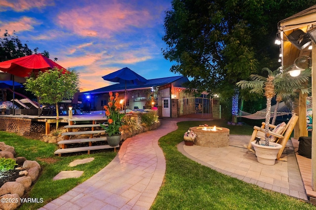 12900 Douglas Rd, Yakima, WA 98908 - yard at dusk with an outdoor fire pit, a wooden deck, and a patio