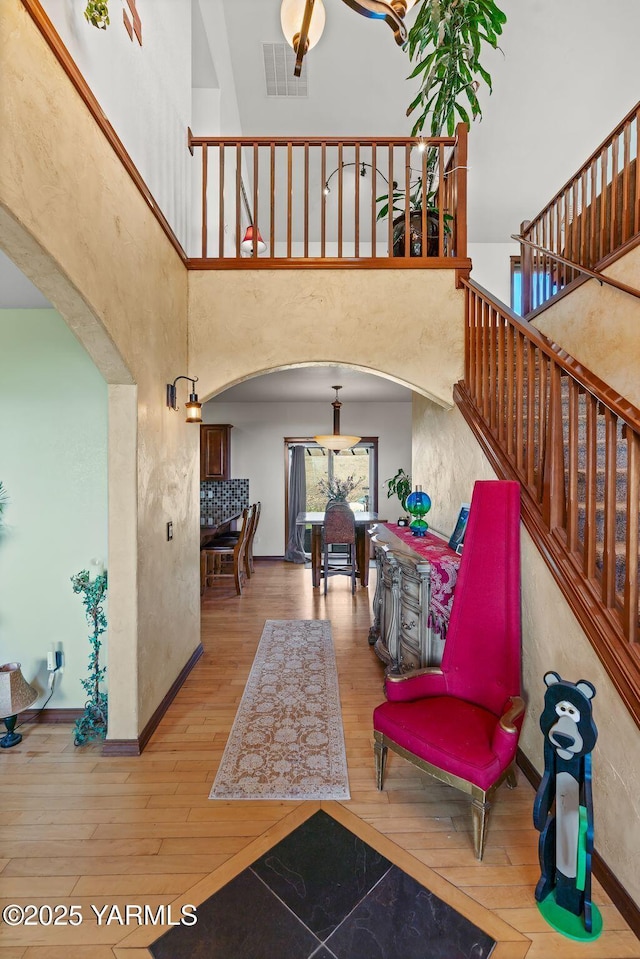 12900 Douglas Rd, Yakima, WA 98908 - entrance foyer with arched walkways, hardwood / wood-style floors, stairs, baseboards, and a high ceiling