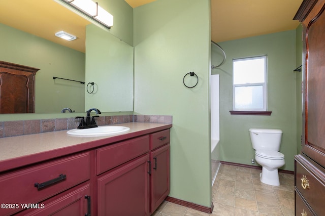 bathroom with shower / washtub combination, baseboards, vanity, and toilet