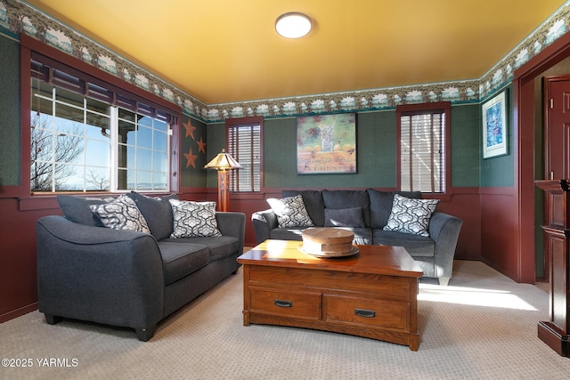 living room with wallpapered walls, wainscoting, and light colored carpet