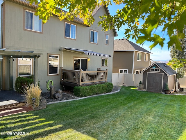 back of property with an outbuilding, a lawn, a deck, and a storage unit