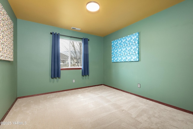 carpeted empty room featuring visible vents and baseboards