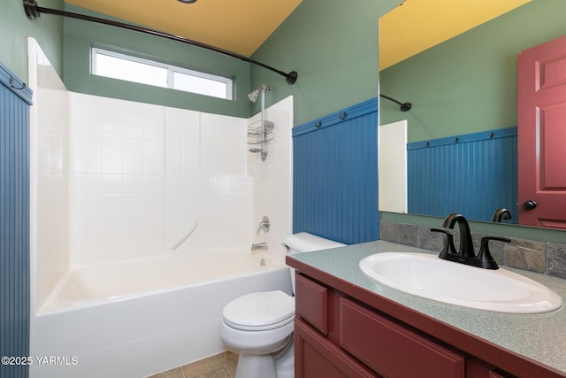 full bathroom featuring wainscoting, toilet, shower / tub combination, tile patterned floors, and vanity