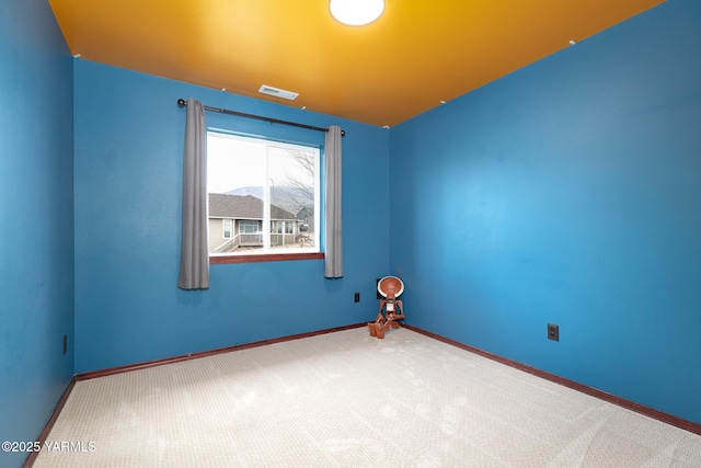 carpeted empty room with visible vents and baseboards