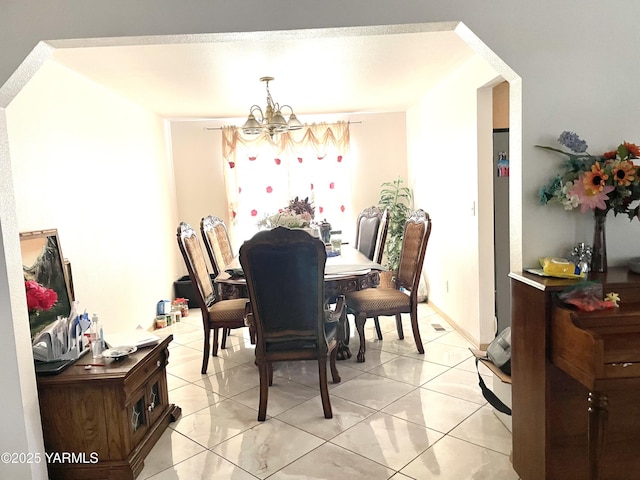 dining area featuring light tile patterned flooring and a chandelier