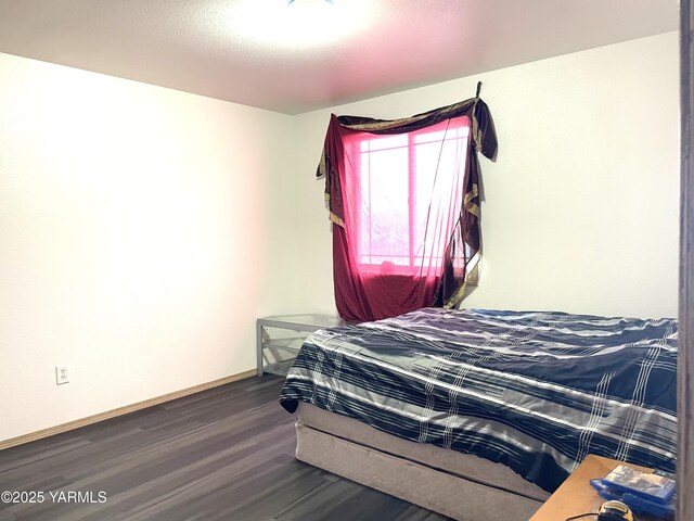 bedroom with wood finished floors and baseboards