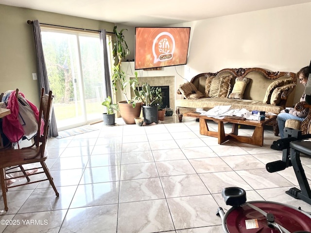 living room featuring a tiled fireplace and light tile patterned floors