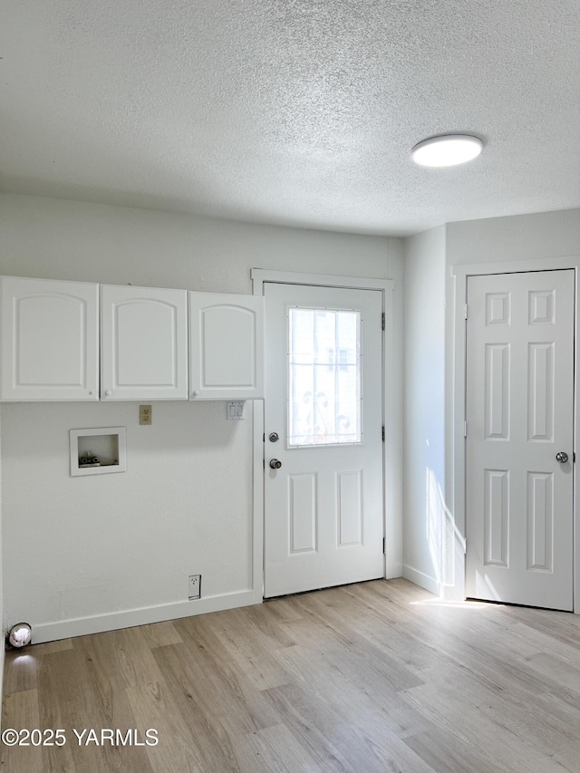 409 Elm Ave, Grandview, WA 98930 - laundry room featuring cabinet space, light wood-type flooring, a textured ceiling, washer hookup, and baseboards