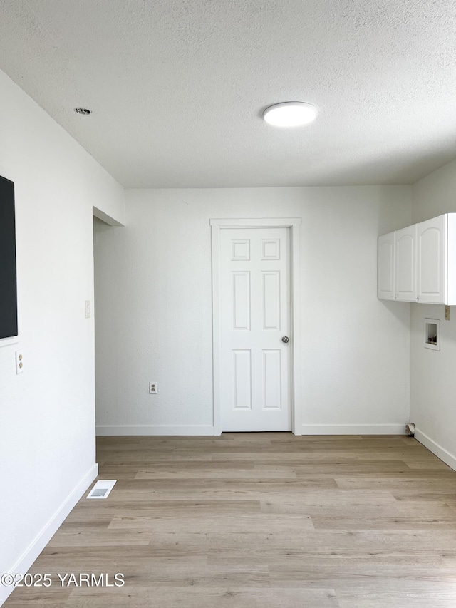 409 Elm Ave, Grandview, WA 98930 - laundry room featuring cabinet space, a textured ceiling, light wood-type flooring, baseboards, and hookup for a washing machine