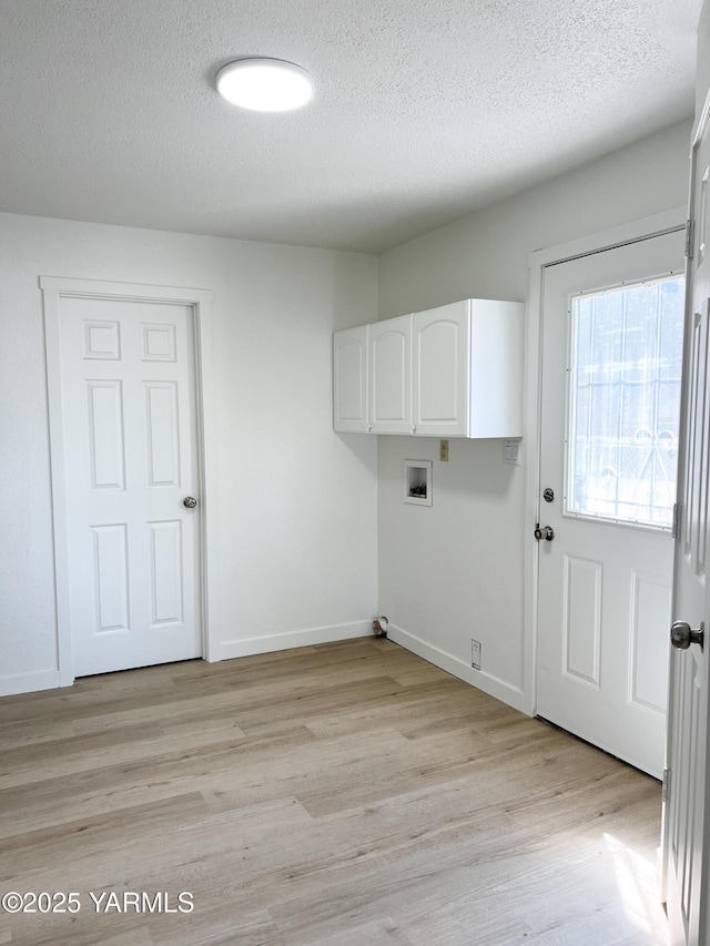 409 Elm Ave, Grandview, WA 98930 - laundry area with cabinet space, hookup for a washing machine, a textured ceiling, light wood-style flooring, and baseboards