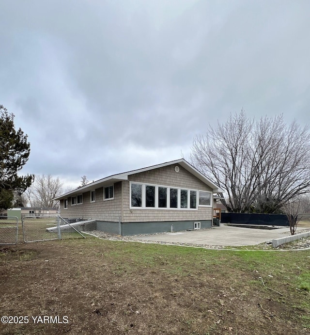 rear view of house with a patio, fence, and a gate