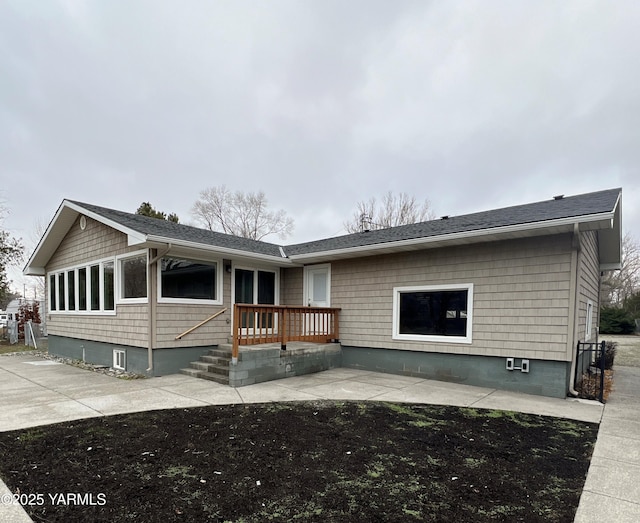 view of front facade with a deck and roof with shingles