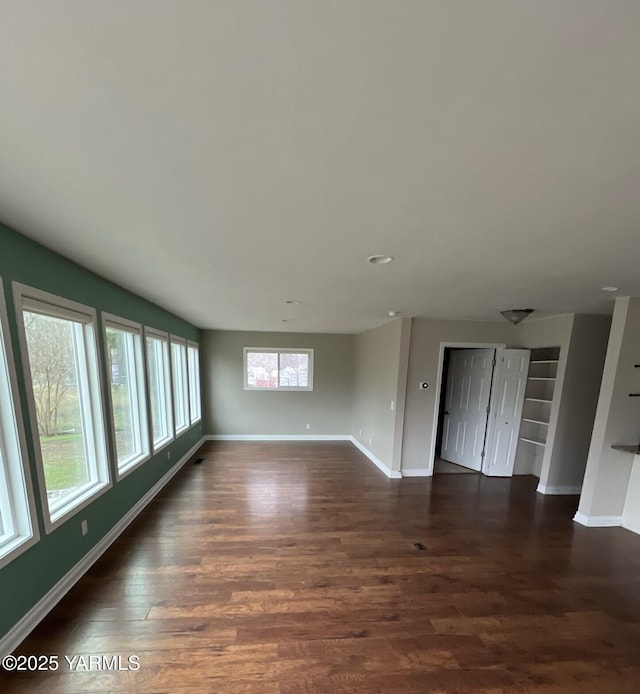 unfurnished room with dark wood-style floors and baseboards