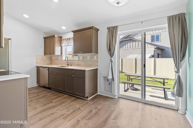 5301 Sage Way, Yakima, WA 98901 - kitchen with stainless steel dishwasher, backsplash, light countertops, light wood finished floors, and recessed lighting