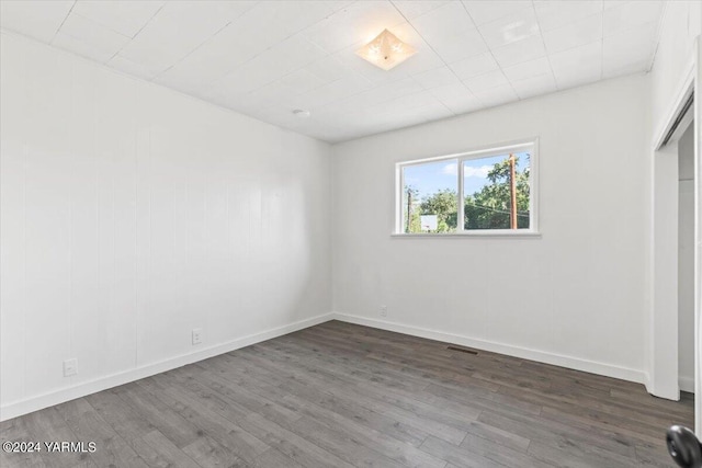 empty room with baseboards and wood finished floors