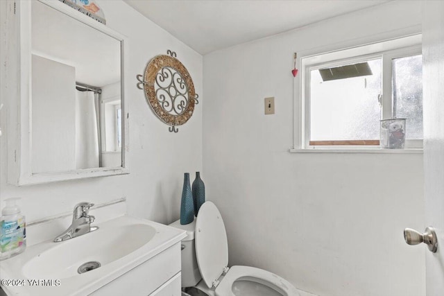 bathroom featuring toilet, a wealth of natural light, and vanity