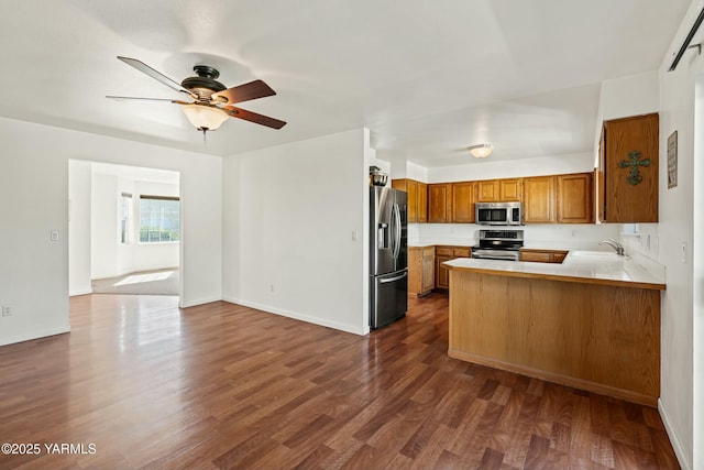 604 N 57th St, Yakima, WA 98901 - kitchen with stainless steel appliances, a sink, dark wood finished floors, a ceiling fan, and brown cabinets