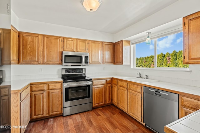 604 N 57th St, Yakima, WA 98901 - kitchen featuring tile counters, a sink, dark wood-type flooring, and appliances with stainless steel finishes