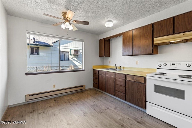 kitchen with light countertops, electric stove, light wood-style floors, under cabinet range hood, and a baseboard heating unit