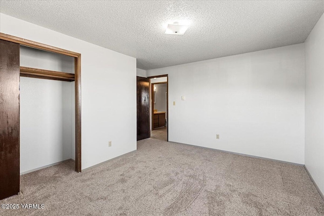 unfurnished bedroom with a closet, carpet floors, and a textured ceiling