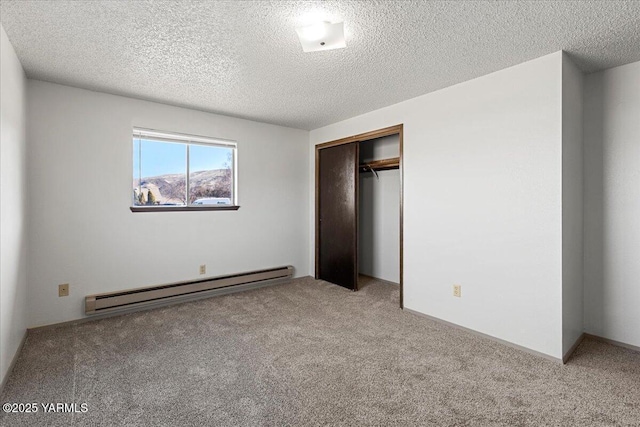 unfurnished bedroom featuring a textured ceiling, a closet, baseboard heating, and carpet