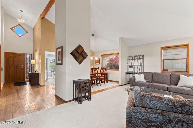 living area featuring lofted ceiling, radiator heating unit, an inviting chandelier, wood finished floors, and baseboards