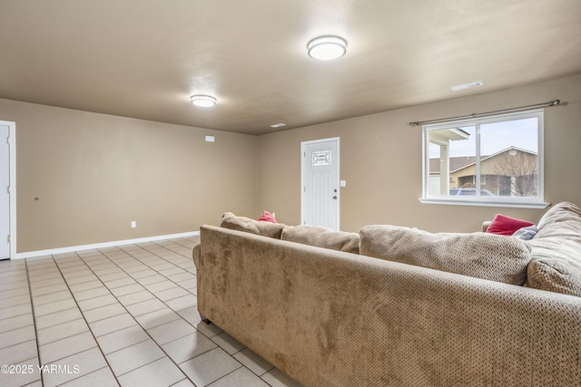 living room featuring light tile patterned floors, visible vents, and baseboards