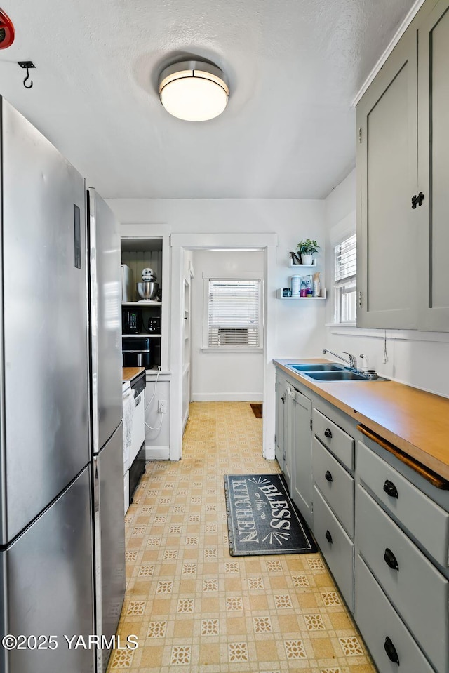 319 S 14th Ave, Yakima, WA 98902 - kitchen with freestanding refrigerator, a sink, open shelves, gray cabinetry, and a textured ceiling