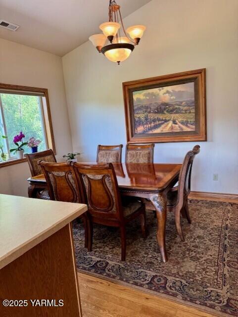 11705 Wide Hollow Rd, Yakima, WA 98908 - dining space featuring light wood-style floors, lofted ceiling, and baseboards
