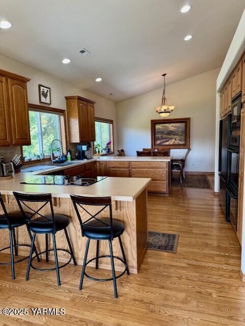 11705 Wide Hollow Rd, Yakima, WA 98908 - kitchen featuring a peninsula, light wood-type flooring, recessed lighting, light countertops, and lofted ceiling