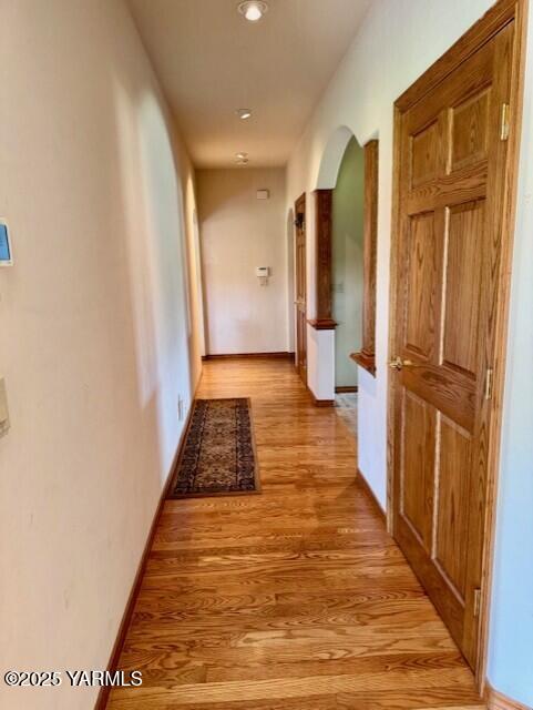 11705 Wide Hollow Rd, Yakima, WA 98908 - corridor with arched walkways, light wood-style floors, and baseboards