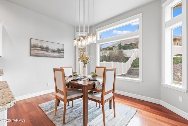 607 N 74th Ave, Yakima, WA 98908 - dining space with visible vents, a notable chandelier, baseboards, and wood finished floors