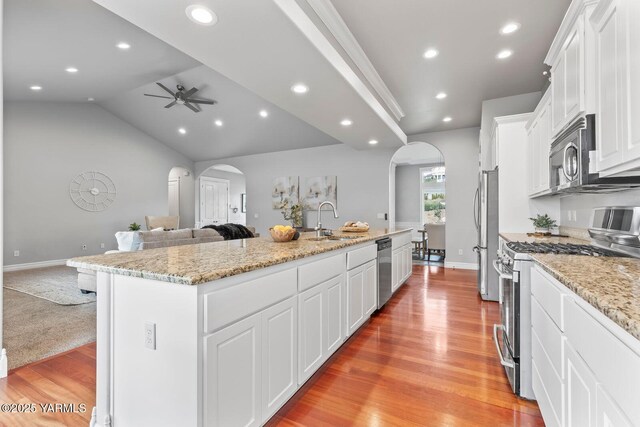 607 N 74th Ave, Yakima, WA 98908 - kitchen with arched walkways, a center island with sink, stainless steel appliances, and open floor plan