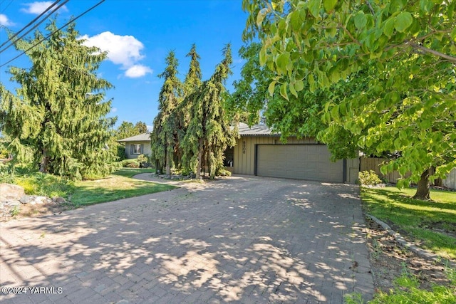 obstructed view of property featuring a garage, driveway, and board and batten siding