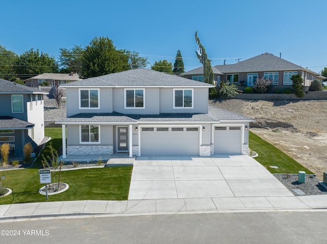 view of front of home with roof with shingles, concrete driveway, an attached garage, stone siding, and a front lawn