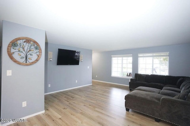 living area featuring light wood finished floors and baseboards