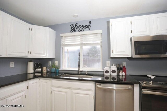 6504 Terry Ave, Yakima, WA 98908 - kitchen featuring dark countertops, appliances with stainless steel finishes, white cabinets, and a sink
