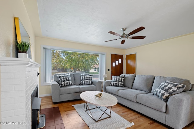 living area featuring ceiling fan, a textured ceiling, and wood finished floors