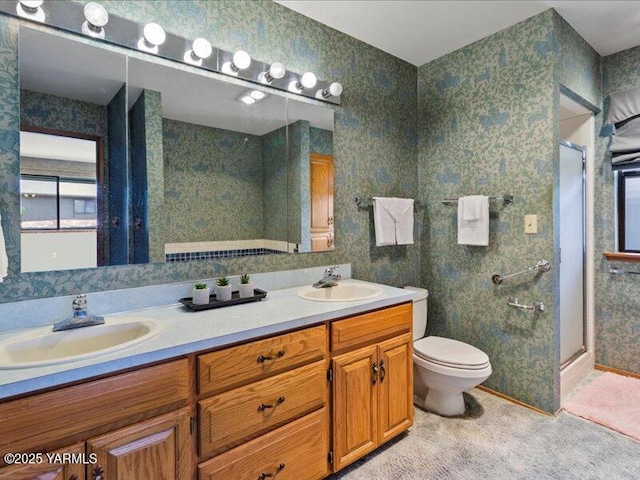 full bath with toilet, double vanity, a sink, and a shower stall