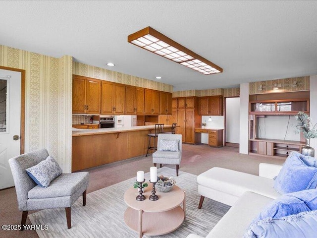 living area with wallpapered walls and light carpet