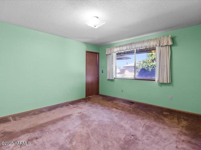 spare room with visible vents, carpet floors, and a textured ceiling
