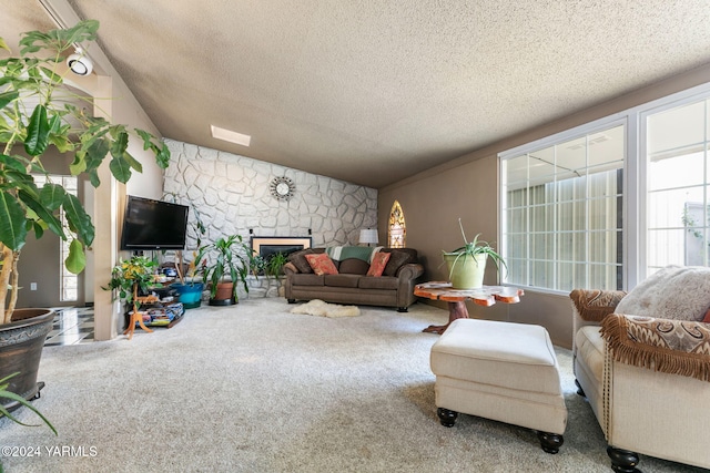 carpeted living area with a textured ceiling and a stone fireplace
