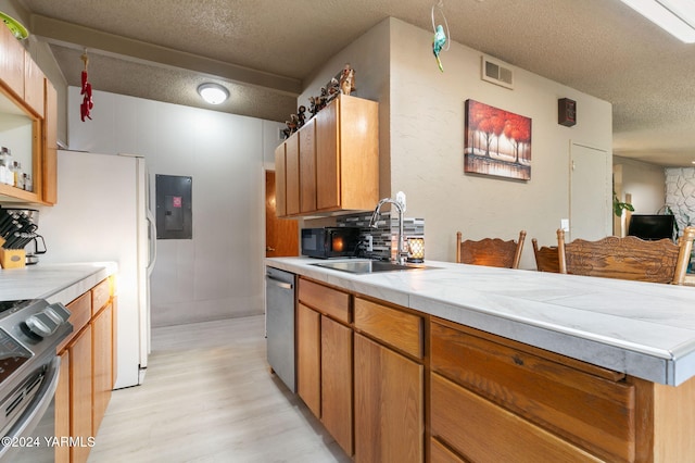 kitchen featuring visible vents, light wood-style floors, a textured ceiling, a sink, and stainless steel appliances