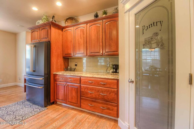 11300 Flintstone Rd, Yakima, WA 98908 - kitchen with high end refrigerator, light wood finished floors, tasteful backsplash, recessed lighting, and brown cabinetry
