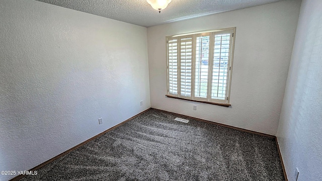 carpeted empty room featuring a textured ceiling, visible vents, and a textured wall