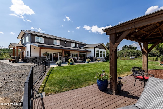 back of property with a yard, a wooden deck, board and batten siding, and a gazebo