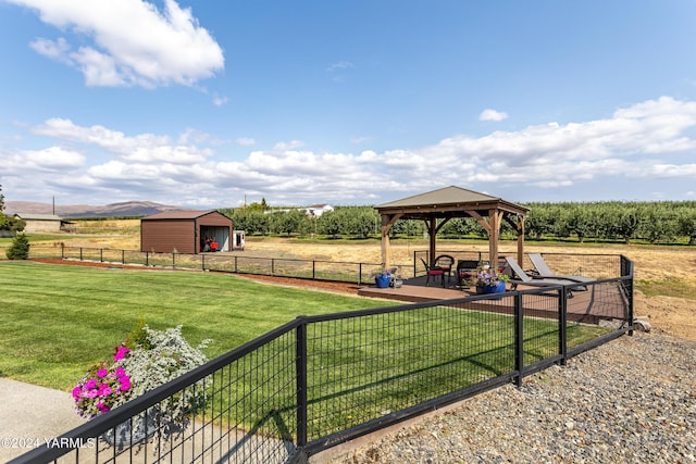 view of yard with a garage, a gazebo, a rural view, and fence