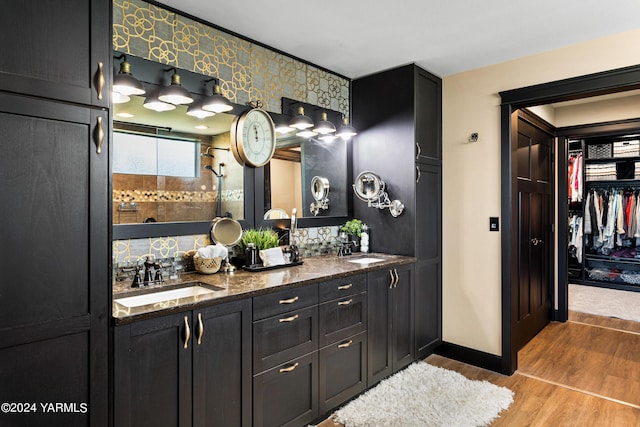 bathroom with double vanity, wood finished floors, and a sink