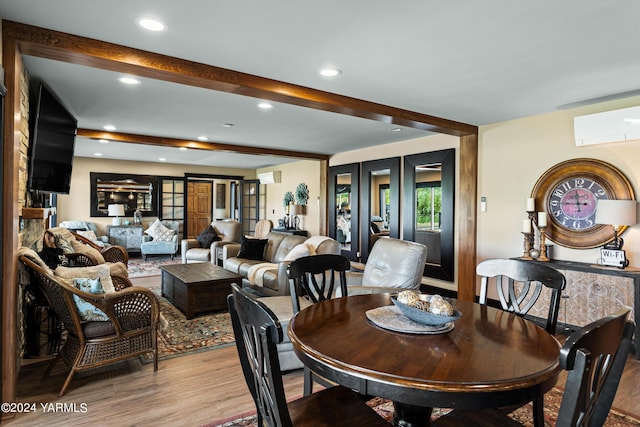 dining area with an AC wall unit, light wood finished floors, beamed ceiling, and recessed lighting