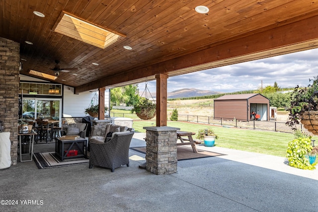 view of patio / terrace with ceiling fan, fence, a mountain view, and outdoor dining space